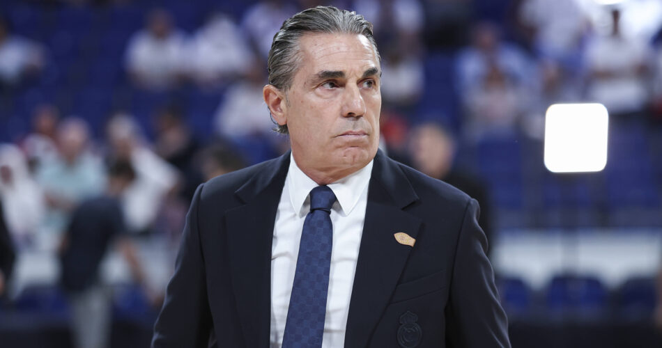 Ο Ιταλός προπονητής Σέρτζιο Σκαριόλο με κοστούμι και γραβάτα της Ρεάλ Μαδρίτης, με προβληματισμένο ύφος κατά τη διάρκεια αγώνα μπάσκετ.